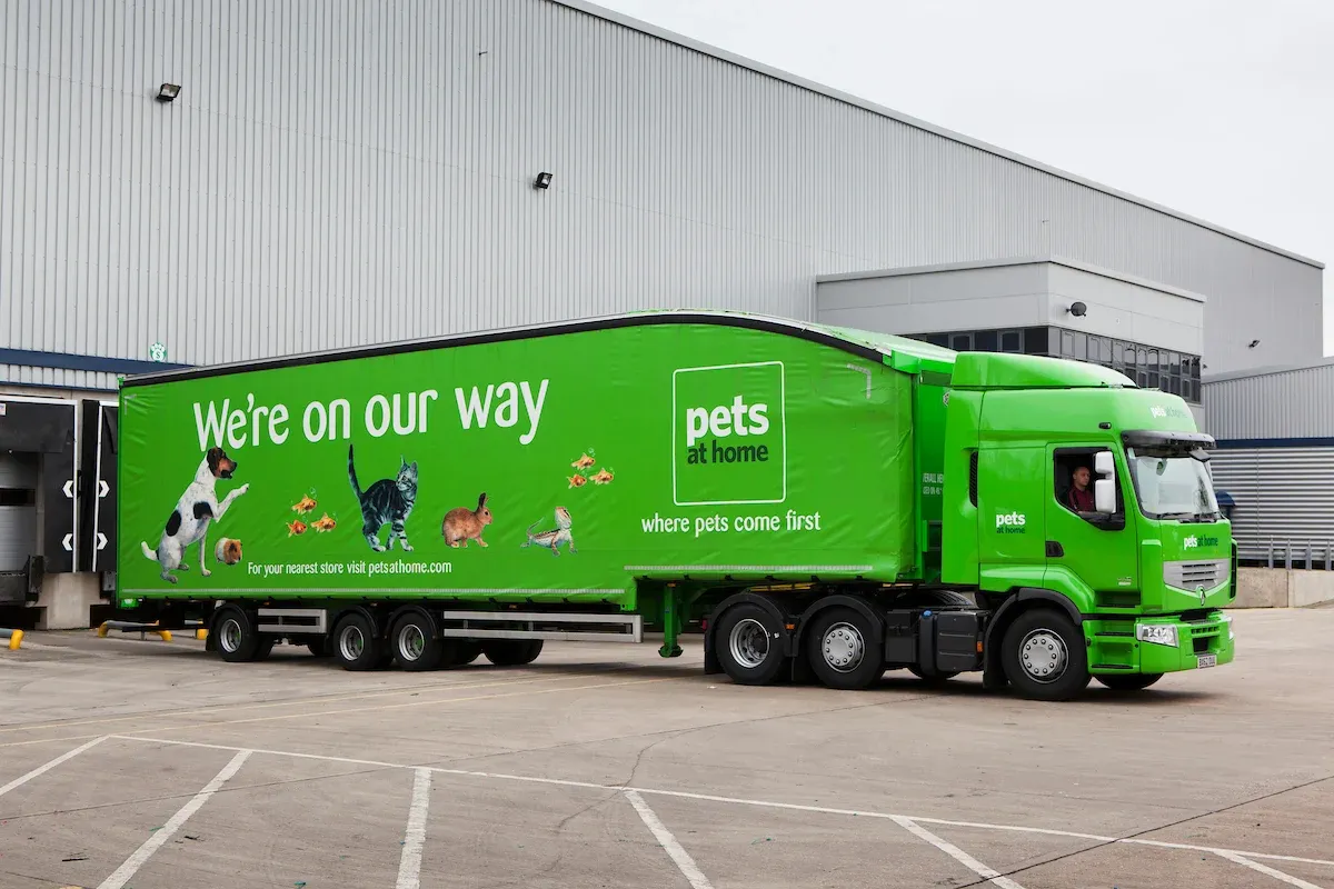 A green Pets At Home lorry parked in a unloading bay