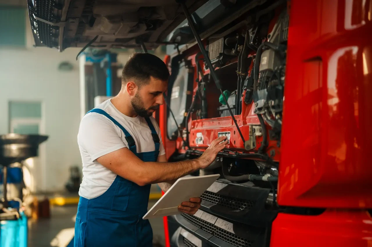 Workshop technician using workshop management software to update job progress and manage maintenance tasks in a commercial vehicle workshop.